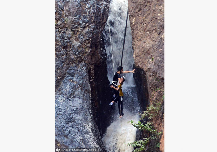 Boy plucked from cliff after falling into waterfall in SW China