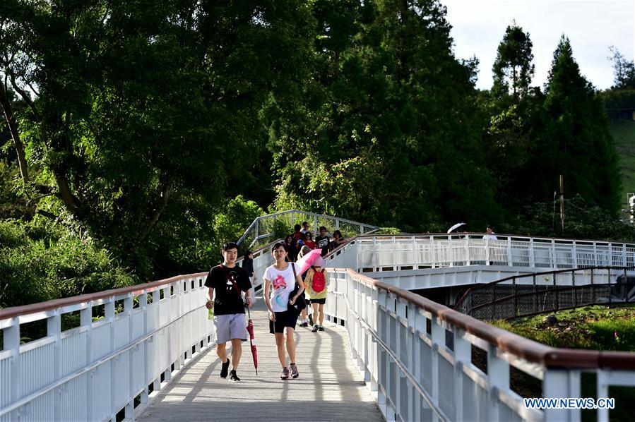 People enjoy scenery at high altitude sight-seeing footpath