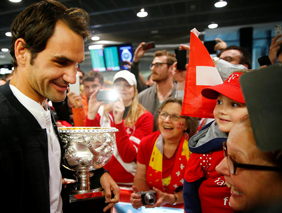 Trophy-holding Federer receives hero's welcome back home