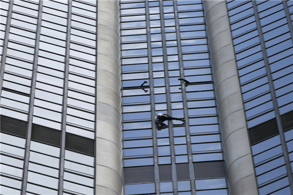 'Spiderman' climbs Paris tower in tribute to quake victims