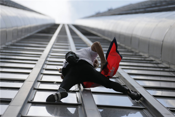 'Spiderman' climbs Paris tower in tribute to quake victims